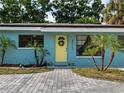 View of a front door with a wreath, surrounded by small palm trees at 4721 W Iowa Ave, Tampa, FL 33616