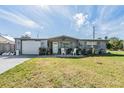 Inviting single-story home featuring a garage and a cozy covered front porch at 5004 Suwannee Dr, New Port Richey, FL 34652