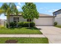 Well-maintained single-Gathering home with green lawn, landscaping, and a two-car garage on a sunny day at 5208 Dandelion St, Apollo Beach, FL 33572