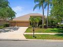 Charming home exterior features a well-maintained lawn and mature landscaping at 5216 Kernwood Ct, Palm Harbor, FL 34685