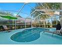 Relaxing screened-in pool area with a blue pool, lounge chairs, and a pleasant outdoor setting at 5520 Terrain De Golf Dr, Lutz, FL 33558
