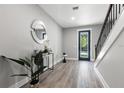 Entryway featuring hardwood floors, staircase with black iron railing, and a decorative mirror at 116 W Stanley St, Tampa, FL 33604
