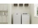 Practical laundry area with a washer, dryer, shelving, cabinets, and a window at 12058 Violet Jasper Dr, Parrish, FL 34219