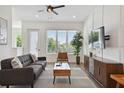 Comfortable living room featuring modern decor, a ceiling fan, and a large window for natural light at 121 E Warren Ave # 1, Tampa, FL 33602