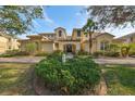 Inviting exterior view of the condo featuring lush landscaping and a covered entryway at 1348 Emerald Dunes Dr, Sun City Center, FL 33573