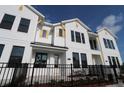 Modern townhome with white siding, black framed windows, yellow accents, and well-maintained landscaping at 1643 Springwell Ln, Sarasota, FL 34240