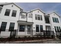 Beautiful townhome showcases a white exterior, black trim, and a decorative black fence at 1643 Springwell Ln, Sarasota, FL 34240