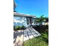 Inviting front entrance with modern walkway, freshly mulched garden and manicured lawn at 1818 Douglas Ave, Dunedin, FL 34698