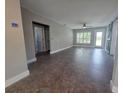 Spacious living room featuring neutral paint, tiled floors, modern fan and a sliding barn door at 1818 Douglas Ave, Dunedin, FL 34698