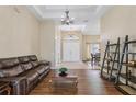 Spacious living room with hardwood floors, coffered ceiling, chandelier and a view into the dining room at 20254 Ravens End Dr, Tampa, FL 33647