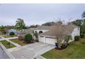 Exterior view of home with lush landscaping, a three-car garage, and inviting curb appeal at 21215 Tyrell Way, Land O Lakes, FL 34638
