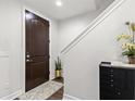 Inviting foyer featuring a dark wood door, staircase, and stylish decor offers a warm greeting at 214 S Audubon Ave, Tampa, FL 33609