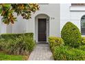 Charming entryway with a dark wood front door, stone pathway, and lush landscaping creates a warm welcome at 214 S Audubon Ave, Tampa, FL 33609