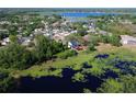 Stunning aerial view of a lakeside home with a private deck, surrounded by lush greenery at 219 Galaxy Ave, Spring Hill, FL 34606
