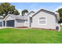 Well maintained single Gathering home with a lush green lawn and three car garage at 2203 Malaga Ave, Spring Hill, FL 34609