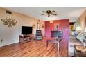Comfortable living room with wood floors, a ceiling fan, and a accent wall with decorative display cabinet at 2284 Philippine Dr # 7, Clearwater, FL 33763