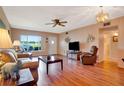 Cozy living room featuring wood floors, a ceiling fan, and a window overlooking the green outdoor space at 2284 Philippine Dr # 7, Clearwater, FL 33763
