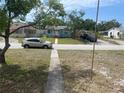 Street view of a light blue single-story home with a walkway, green grass, and parked cars at 2435 37Th N Ave, St Petersburg, FL 33713