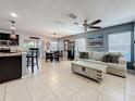 Open-concept living room and dining area features tile flooring and ample natural light at 2530 Sandy Beach Ln, Clearwater, FL 33763