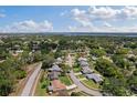 Aerial view of a neighborhood featuring tree-lined streets, well-manicured lawns, and a lake in the distance at 2810 Doone Cir, Palm Harbor, FL 34684
