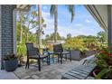 Cozy covered patio featuring comfortable seating and views of the landscaped yard at 2810 Doone Cir, Palm Harbor, FL 34684