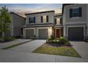 Charming two-story townhome with gray stucco, shutters, and attached garages at 31970 Blue Passing Loop, Wesley Chapel, FL 33545