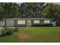 Inviting single-story home featuring a lush green lawn and a cheery yellow front door at 3302 W Beaumont St, Tampa, FL 33611