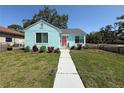 Inviting single-story home with light blue siding, complemented by a lush green lawn and quaint walkway at 3501 7Th N Ave, St Petersburg, FL 33713
