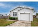 Single-Gathering home featuring a well-manicured lawn and a two-car garage at 3730 Elmwood Dr, Holiday, FL 34691