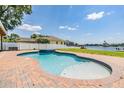 Inviting backyard pool overlooking a serene lake, perfect for relaxation and outdoor entertainment at 3938 Lake Joyce Dr, Land O Lakes, FL 34639