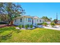 Inviting single-story home with a lush green lawn, complemented by vibrant landscaping and a welcoming entrance at 5030 9Th S Ave, Gulfport, FL 33707