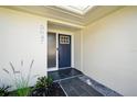 Inviting front entry with gray tiles and a contemporary navy blue front door at 5647 110Th Way, Seminole, FL 33772