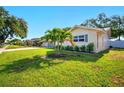 Beautifully landscaped front yard with green grass, palm trees and mature landscaping at 5647 110Th Way, Seminole, FL 33772