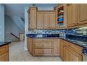 Close-up of the kitchen with custom wood cabinets, modern tile backsplash, granite counters, and stainless steel appliances at 620 Bayway Blvd # 1, Clearwater, FL 33767