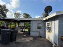 Side of gray house with covered area, trash cans, and satellite dishes on the roof at 6206 Paul Buchman Hwy, Plant City, FL 33565