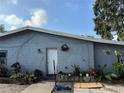 Gray house exterior featuring a small front garden area with various potted plants and a wreath on the front door at 6206 Paul Buchman Hwy, Plant City, FL 33565