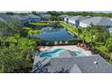 Overhead view featuring a community pool and pond surrounded by well-maintained homes and lush greenery at 6304 Parkside Meadow Dr, Tampa, FL 33625
