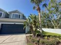Charming exterior view showcasing a blue home with a well-manicured lawn and mature landscaping at 6304 Parkside Meadow Dr, Tampa, FL 33625