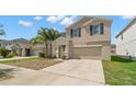Two-story home with a two-car garage and a well-manicured front yard and a sidewalk out front at 6708 Hazelnut Spice Dr, Ruskin, FL 33573