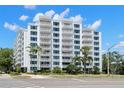 Striking exterior view of Harbour Hill condo with multiple stories and numerous balconies, palm trees, and lush greenery at 700 Beach Ne Dr # 803, St Petersburg, FL 33701