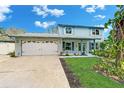 Traditional light blue two-story home with a white garage and a well-maintained front lawn at 9410 Alanbrooke St, Temple Terrace, FL 33637