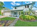 Charming two-story light blue home with white trim, shutters, and landscaped front yard at 9410 Alanbrooke St, Temple Terrace, FL 33637