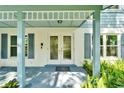 Inviting front porch featuring double doors, shutters, and manicured landscaping at 9410 Alanbrooke St, Temple Terrace, FL 33637