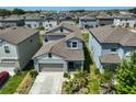 Aerial view of a light blue two-story home surrounded by similar houses in a suburban neighborhood at 9914 Calypso Orchid Ct, Riverview, FL 33578