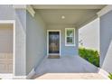 Inviting front porch with a black front door, neutral mat, and manicured landscaping at 9914 Calypso Orchid Ct, Riverview, FL 33578