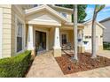 Inviting front porch with stylish columns, a charming seating area, and a view of the manicured landscaping at 2207 Climbing Ivy Dr, Tampa, FL 33618
