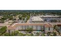 Aerial view of a multi-unit complex with a pool, landscaping, and shopping center nearby at 1216 S Missouri Ave # 108, Clearwater, FL 33756