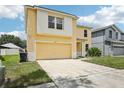 Two-story home with attached garage and front yard at 13506 Copper Belly Ct, Riverview, FL 33569