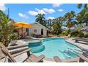 Backyard pool with spa, surrounded by lush tropical landscaping, and including lounge chairs and an umbrella at 146 8Th Ne Ave, St Petersburg, FL 33701
