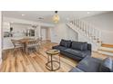 Open-concept living area with hardwood flooring, modern furnishings, and a staircase at 1577 Chateaux De Ville Ct, Clearwater, FL 33764